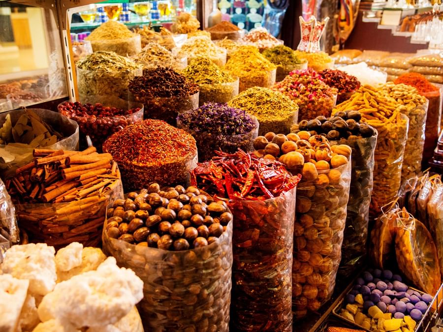 An array of spices and dried fruits on display at a market near DAMAC Hotels & Resorts