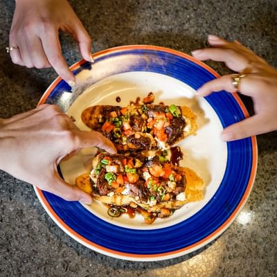 Delicious gourmet bruschetta appetizers served on a blue-rimmed plate in Doe’s Eat Place at Margaritaville Resort Biloxi