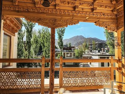 Interior of a balcony overlooking the mountains & buildings at The Indus Valley, stay in Ladakh