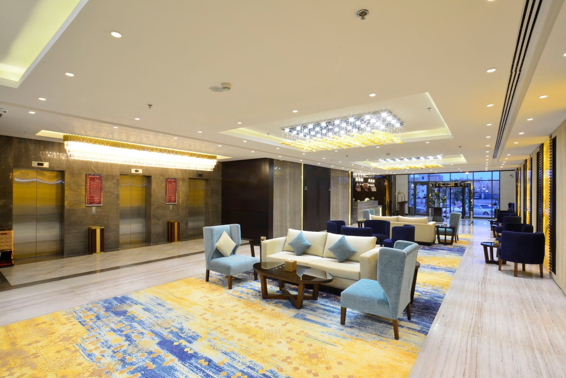 Elevator lobby, featuring light blue chairs near a cream sofa under chandeliers at Naviti By Warwick Dammam