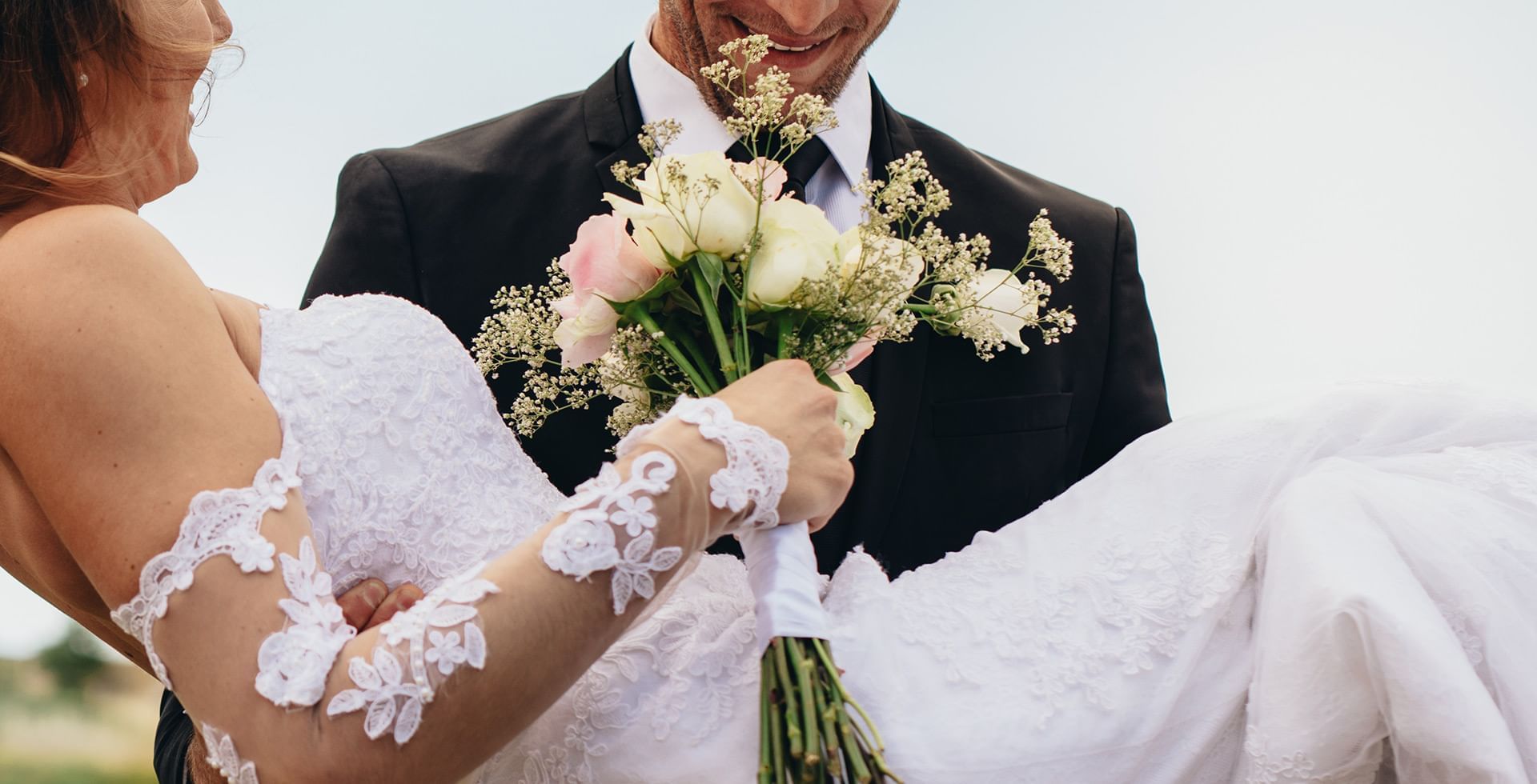 Groom carrying the bride near Midnight Sun, a Coast Hotel