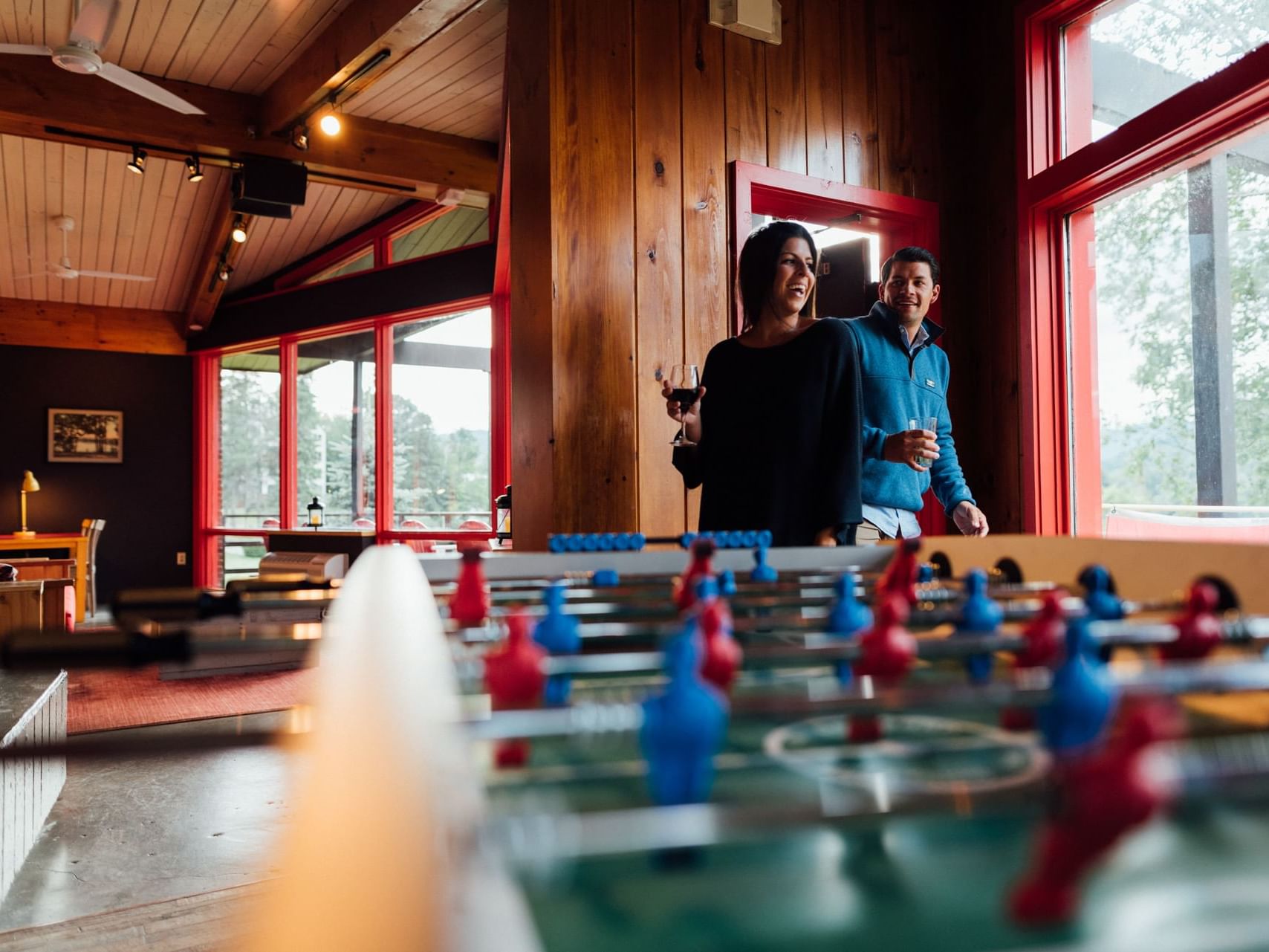 Couple holding drinks at the bar at Lake House in Peaks Resort