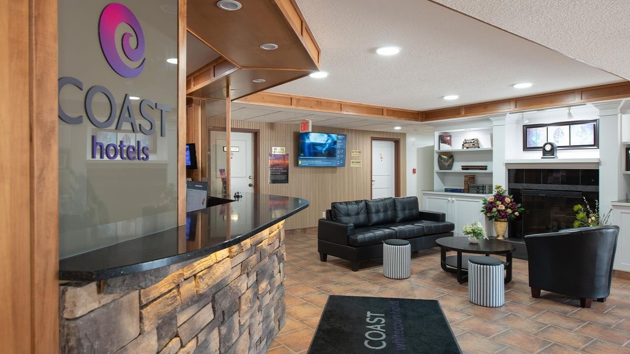 hotel front desk and lobby with seating area at Coast Whitecourt Hotel