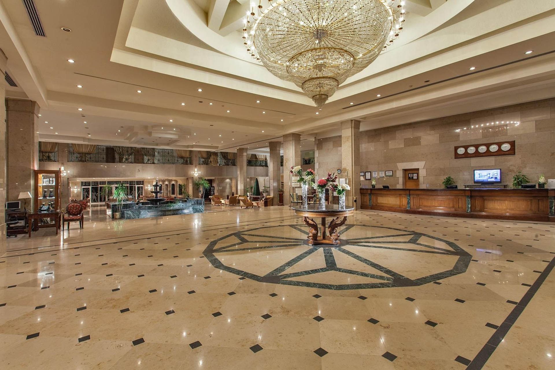 Spacious lobby at Pickalbatros Golf Beach Resort with a grand chandelier, elegant decor, and a welcoming reception desk