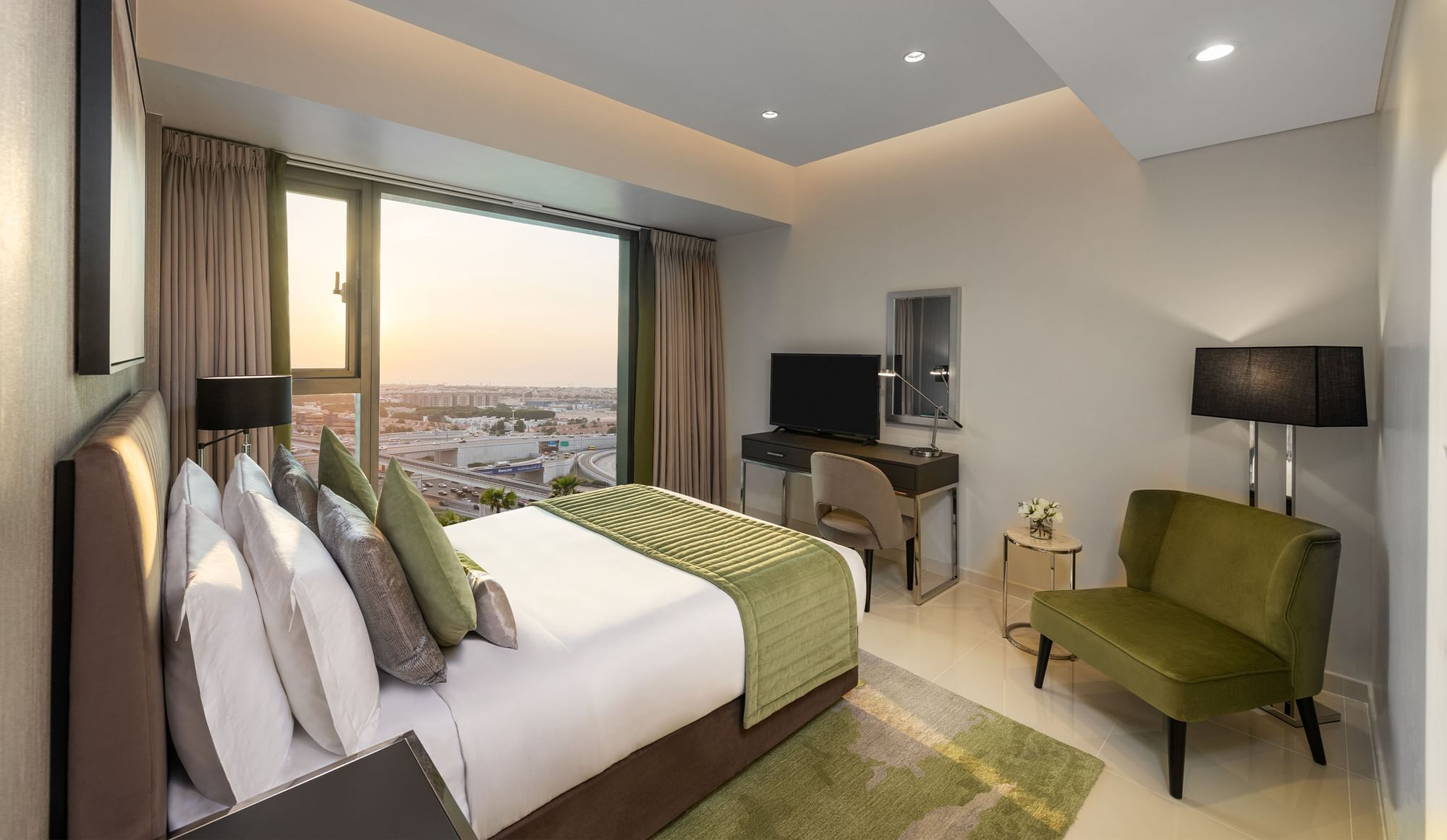 TV & cozy lounge chair facing the bed in Three Bedroom at DAMAC Maison Aykon City