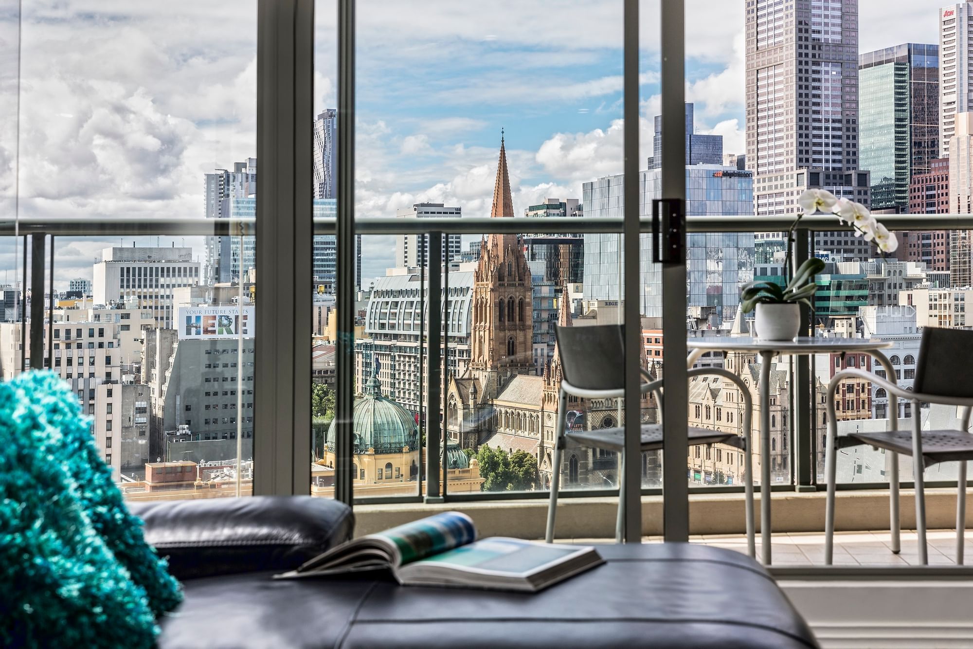 Magazine on a sofa with a city view at Quay West Suites Melbourne