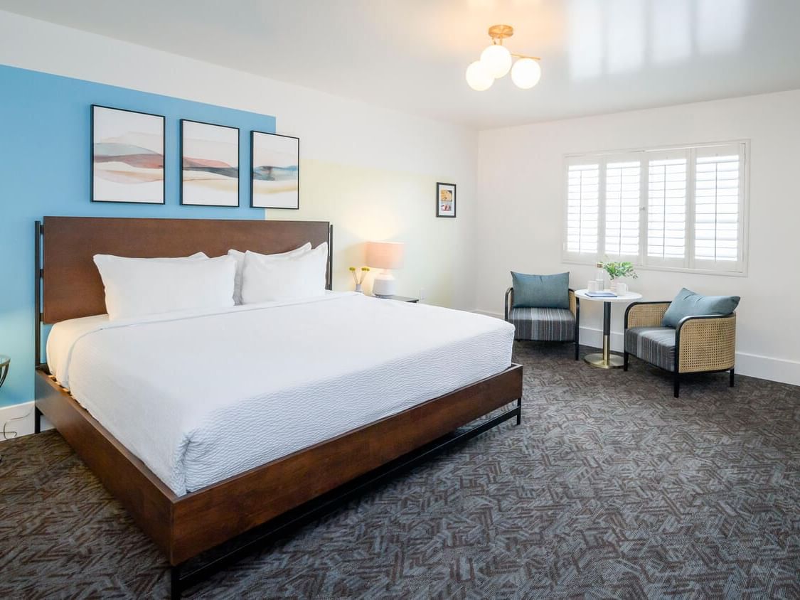 Bed and seating area with carpeted floors in Deluxe King Room at Beck's Motor Lodge San Francisco