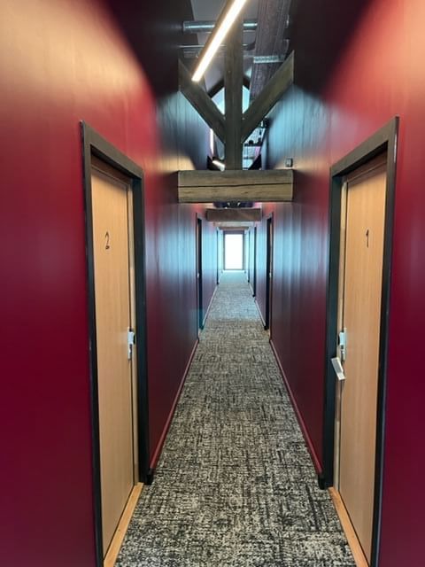 A passage with room entrances at The Originals Hotels
