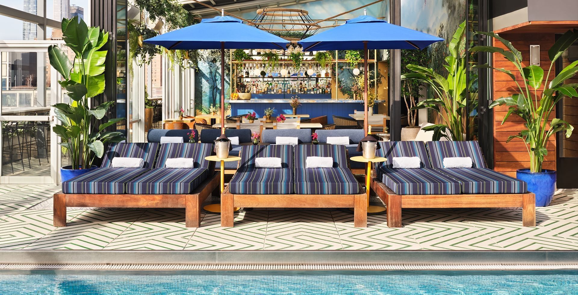 Swimming pool on Gansevoort rooftop with lounge chairs and umbrellas at Gansevoort Meatpacking NYC