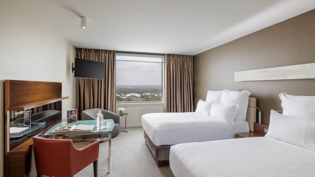 Work desk with TV facing two beds by the window in Deluxe Room - Two Double Beds at Pullman Sydney Olympic Park