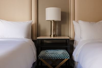 Cozy beds with nightstand and stool in Deluxe Two Double Beds Room at Hotel Bijou, featuring San Francisco accommodation