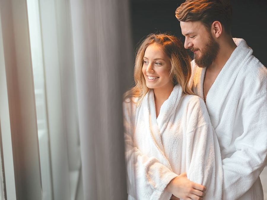 A couple wearing bathrobes in a room at Delfines Hotel