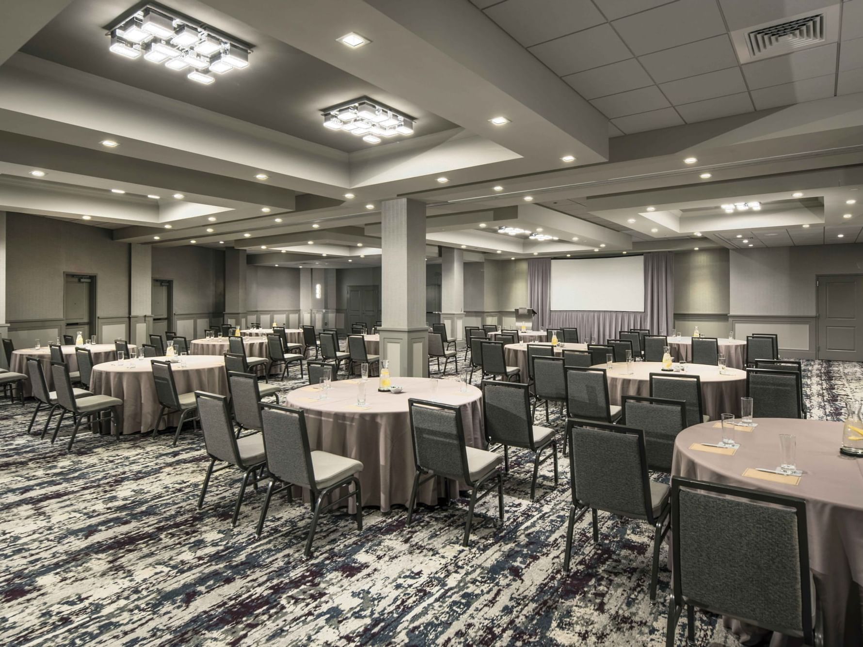 banquet room with tables, chairs and projection screen