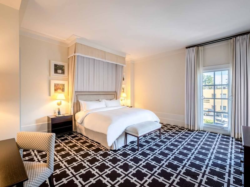 Accessible King Room featuring a large bed, stylish decor, and a striking geometric patterned carpet at El Prado Hotel
