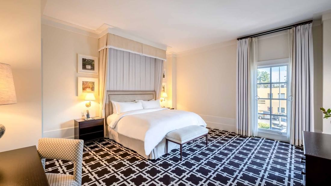 Accessible King Room featuring a large bed, stylish decor, and a striking geometric patterned carpet at El Prado Hotel