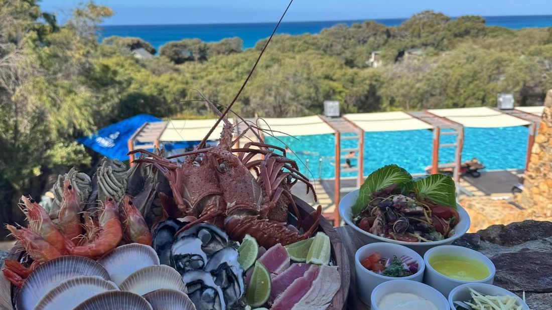 Plate of seafood with a pool view in the Festive In-Villa Indulgence offer.
