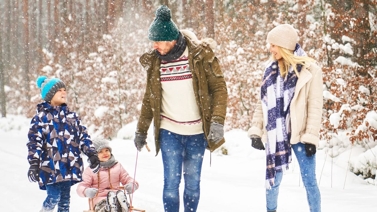 Family walking in the woods during snow