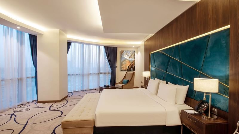 Panorama Suite with cozy bed with lamps at Warwick Riyadh
