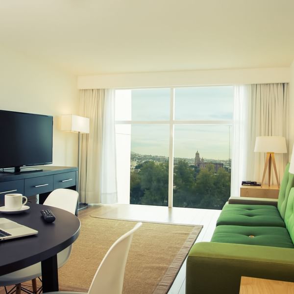 Living area with city view in Junior Suite at Fiesta Inn