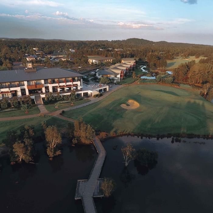 Aerial view of Mercure Kooindah Waters beside a golf course with green fairways and a pond