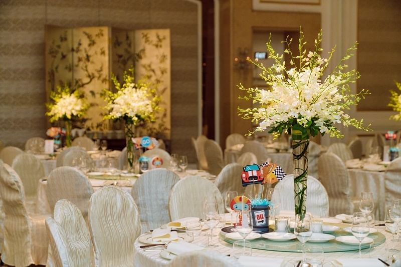 Elegant dining setup featuring white floral centerpieces, stylish chairs, and playful decorations at Park Hyatt Saigon