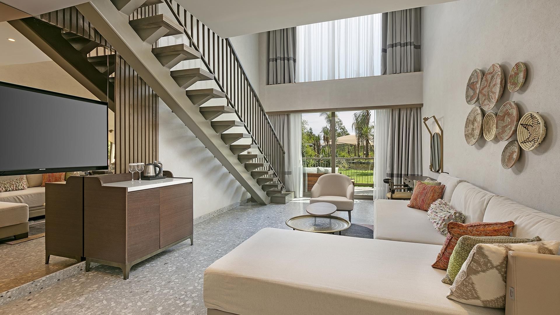 Living room with TV, staircase and view of the outdoors in Family Duplex at Cullinan Belek