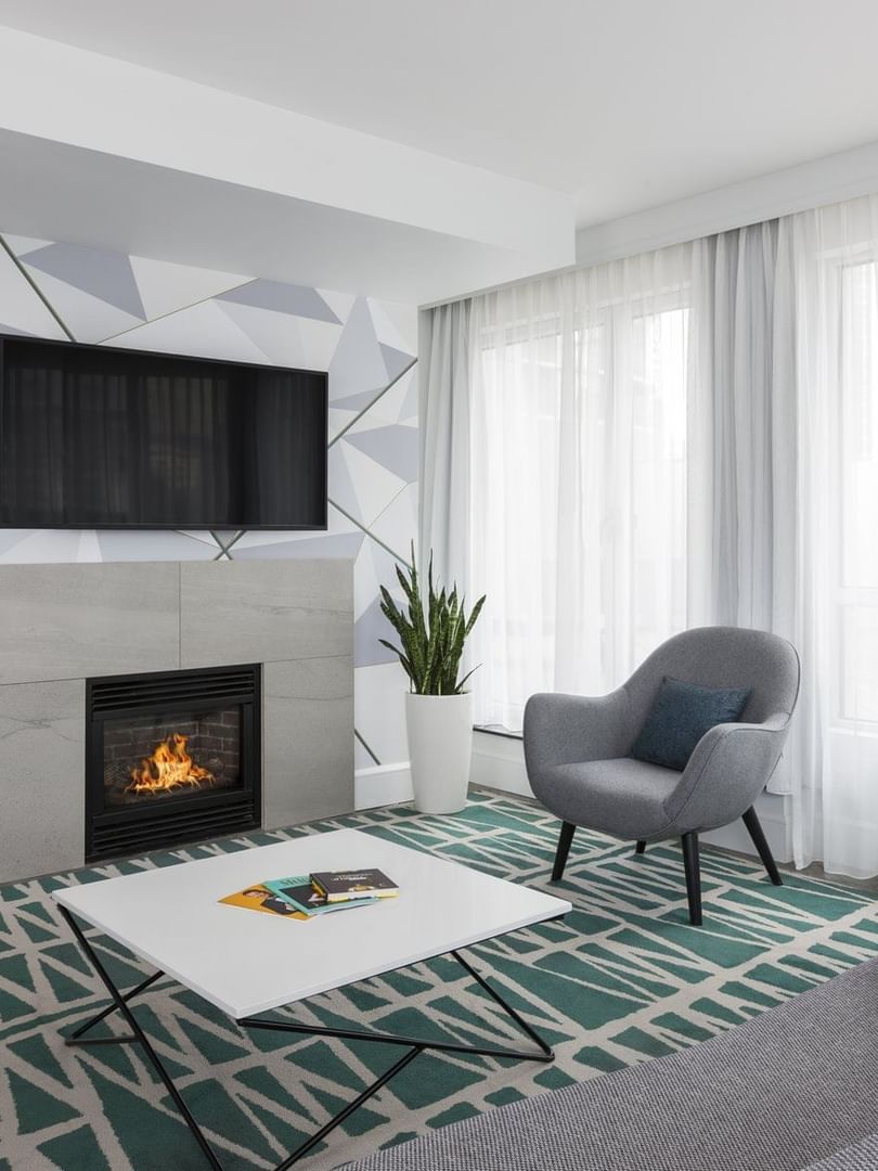 TV lounge with fireplace and sofa near window in Penthouse René-Lévesque at Warwick Le Crystal Montreal