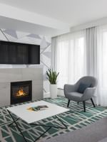 TV lounge with fireplace and sofa near window in Penthouse René-Lévesque at Warwick Le Crystal Montreal