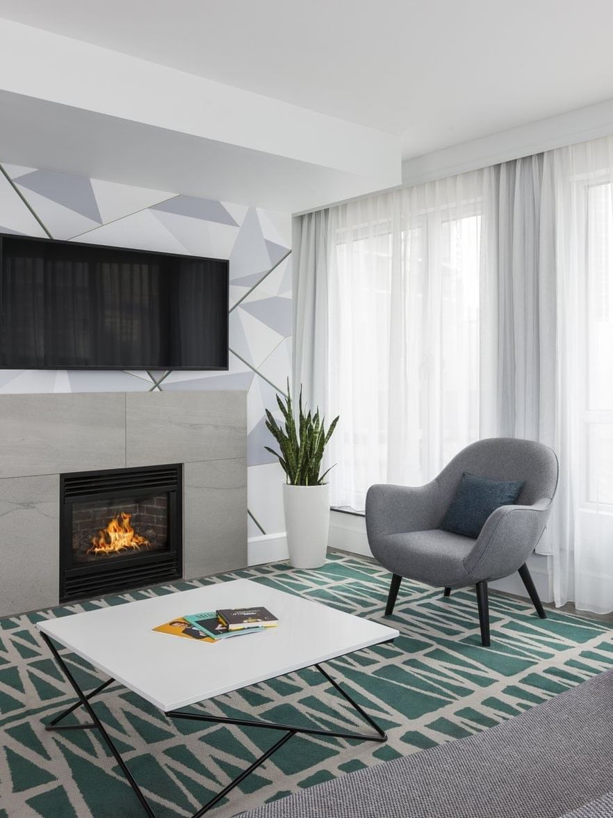 Elegant living room with fireplace, TV, and cozy seating at Warwick Le Crystal – Montreal.