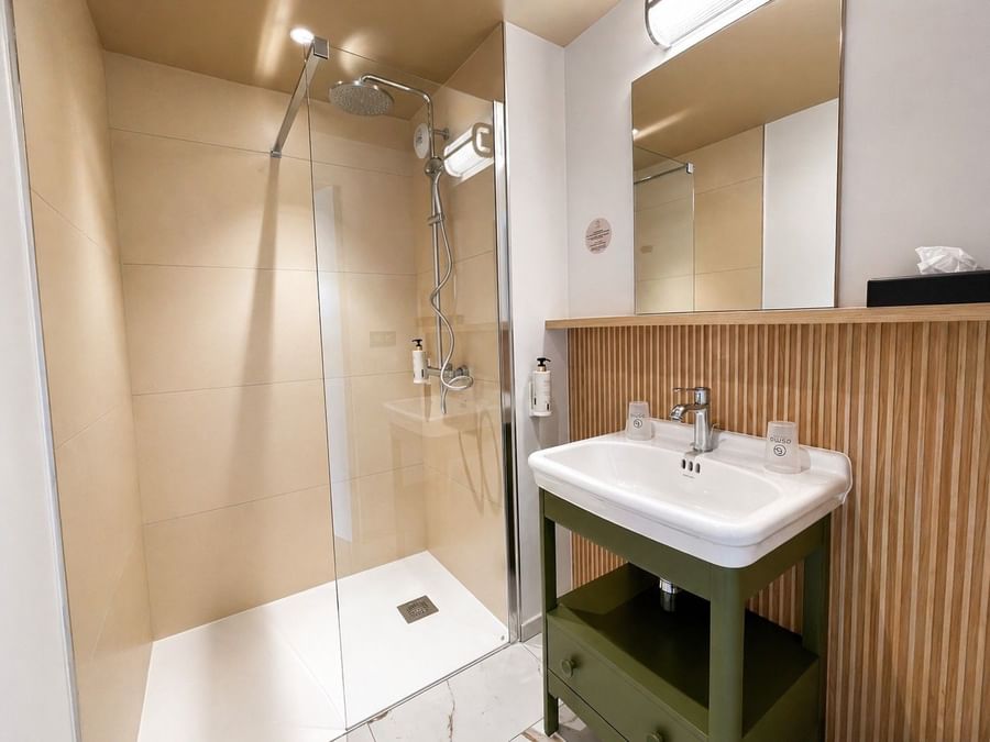 Salle de bain moderne avec douche et lavabo à l'Osmo Hôtel à Chantepie.