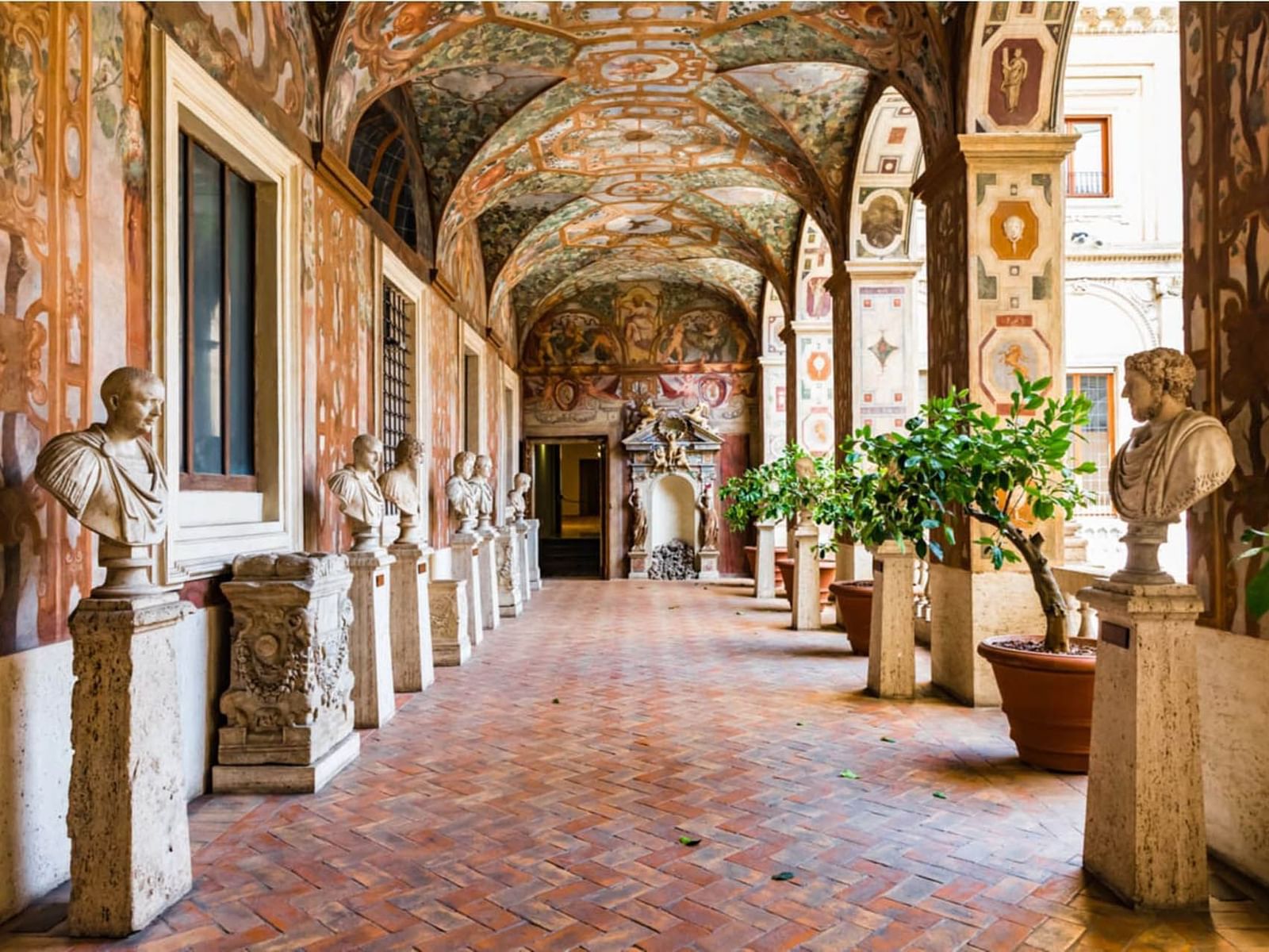 Ornate hallway with classical Roman busts and painted ceilings near The Guardian Hotel