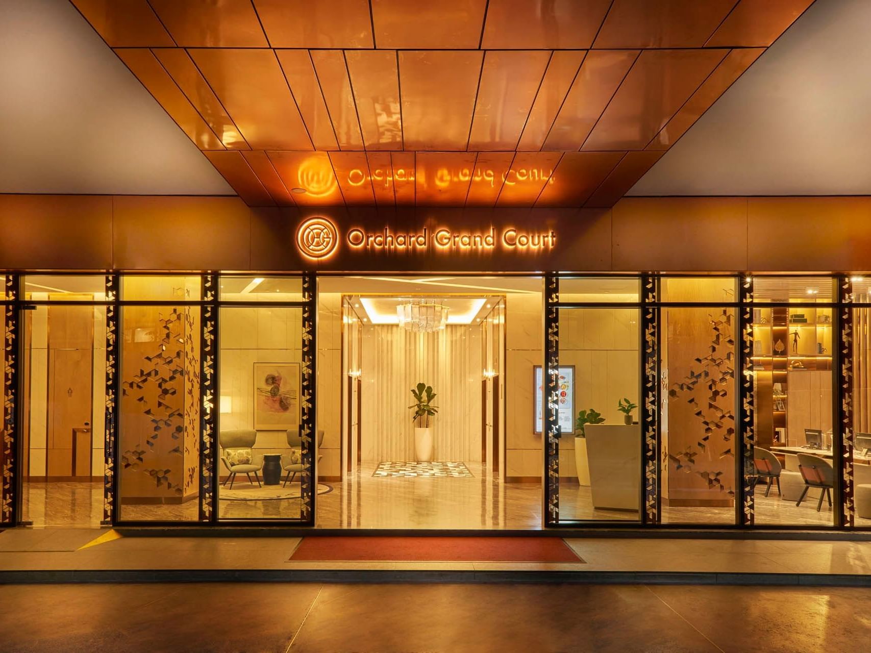 Elegant exterior view of the lobby entrance with the hotel sign at Orchard Grand Court
