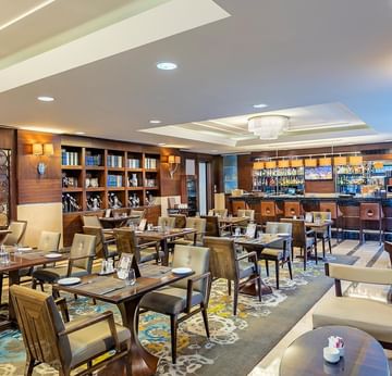 An elegant restaurant featuring tables, chairs, and a bar area with shelves and decorative elements in Titanic Coffee at Titanic Port Bakırköy
