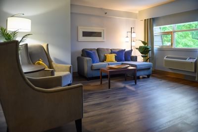 Two Queen Suite featuring grey sofa & table, with armchairs at Rodd Moncton, premium accommodation in Moncton, New Brunswick