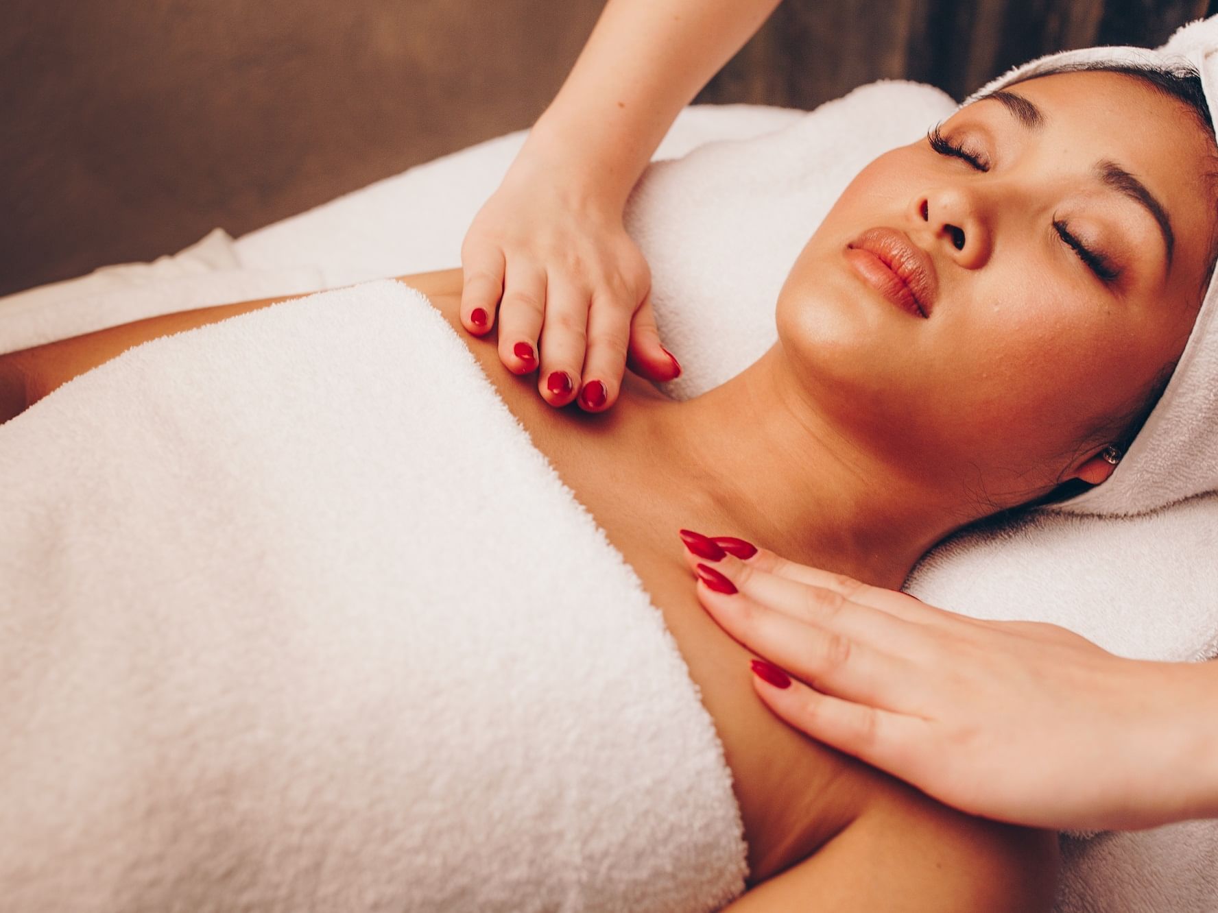 Woman receiving a relaxing body massage in a spa at The Londoner Hotel