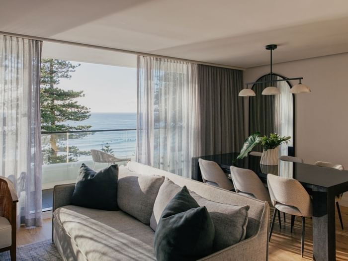 Coastal Two Bedroom Suite at Elysium Manly with a grey sofa by sheer curtains under a pendant light near an arched mirror