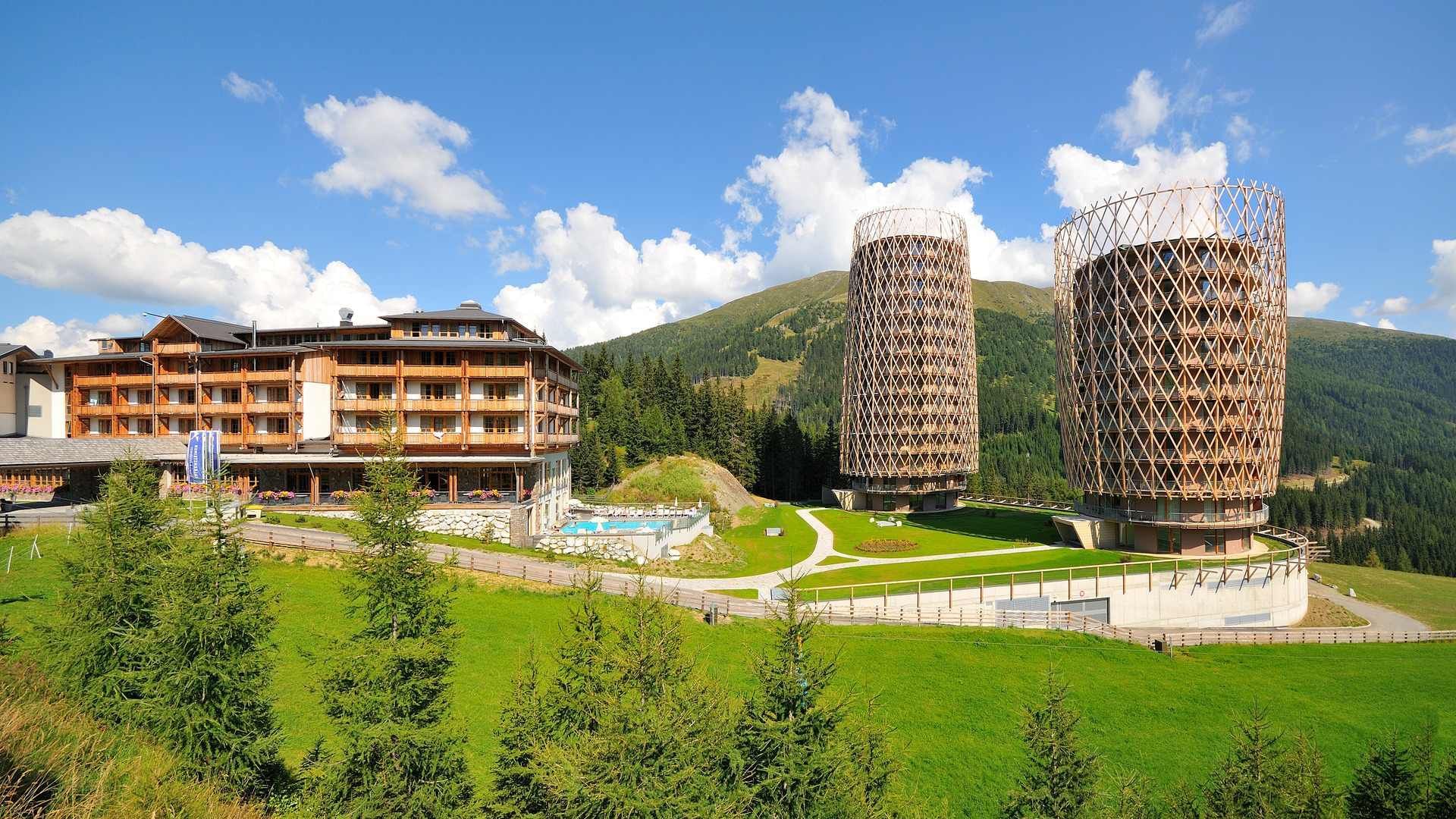 Exterior view of Falkensteiner Residences Edelweiss with green lawns & mountain backdrop