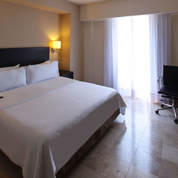 King bed with working desk in Superior Room at Fiesta Inn