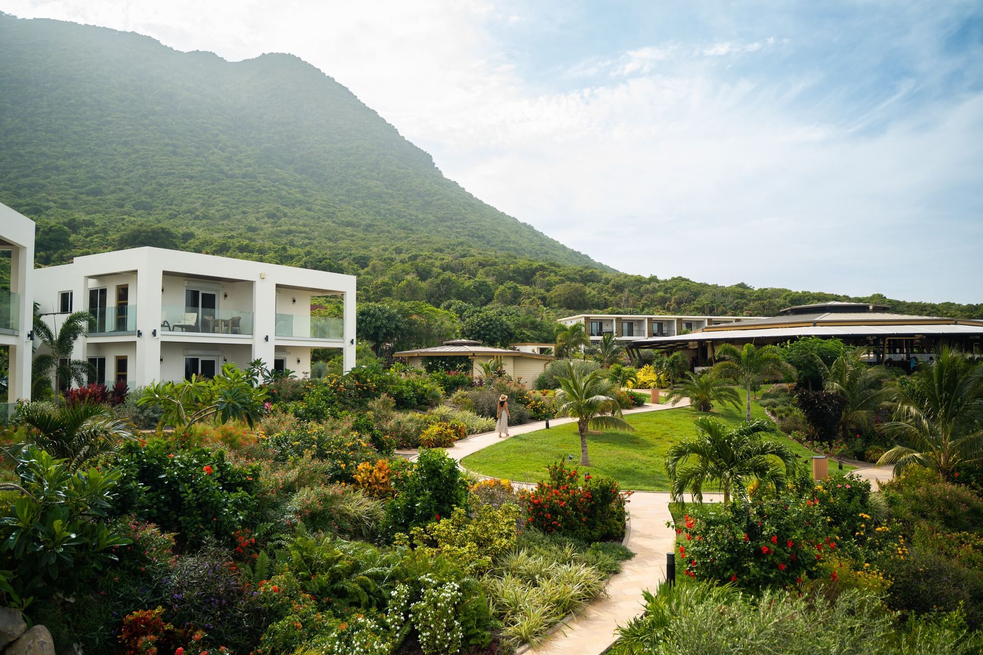 Rustig uitzicht op moderne villa’s en weelderige tuinen met een mistige berg op de achtergrond bij Golden Rock Resort