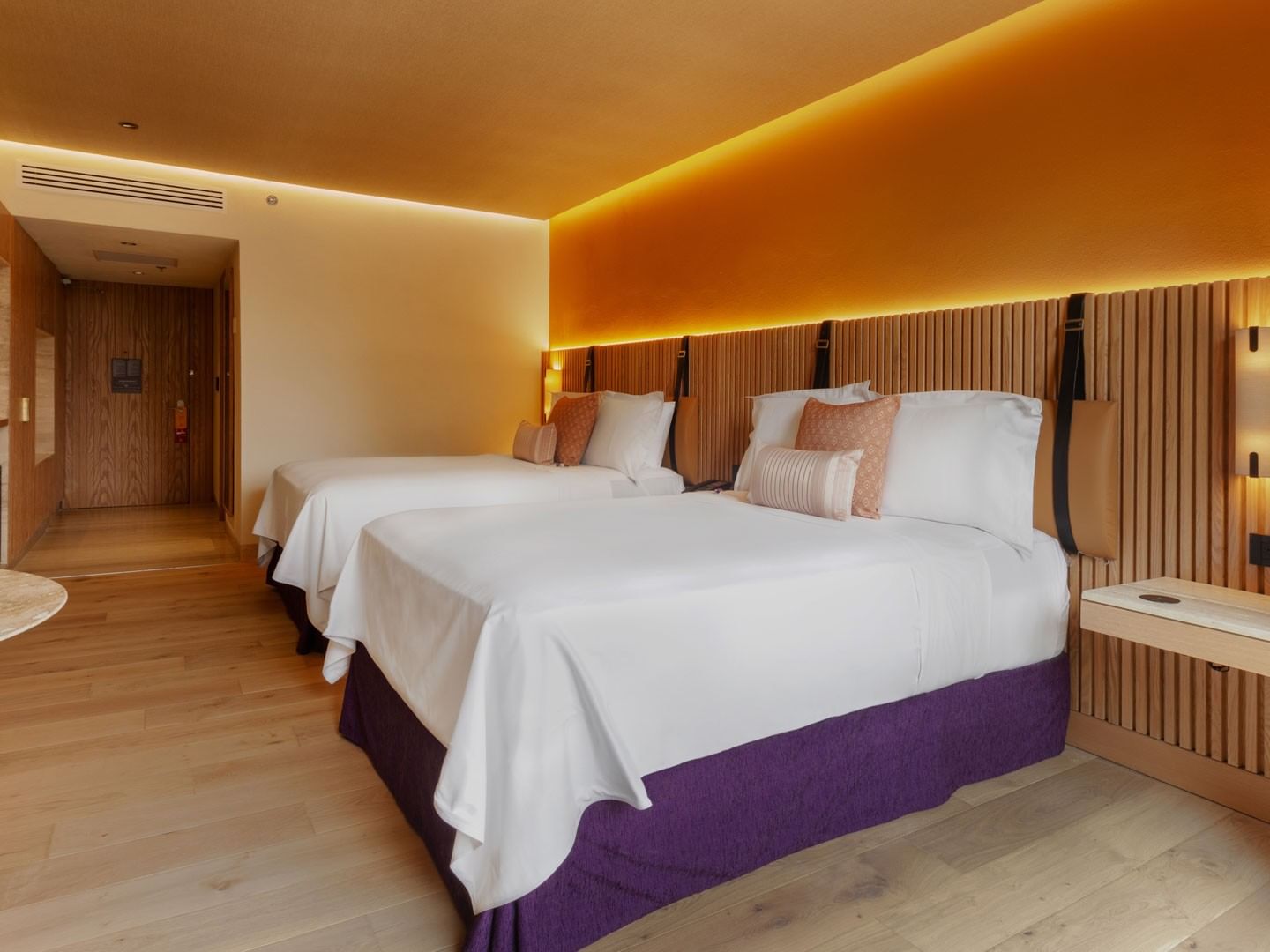 2 Double Superior Camino Real Club with headboards, purple bed skirts, and warm tones at Camino Real Polanco Mexico