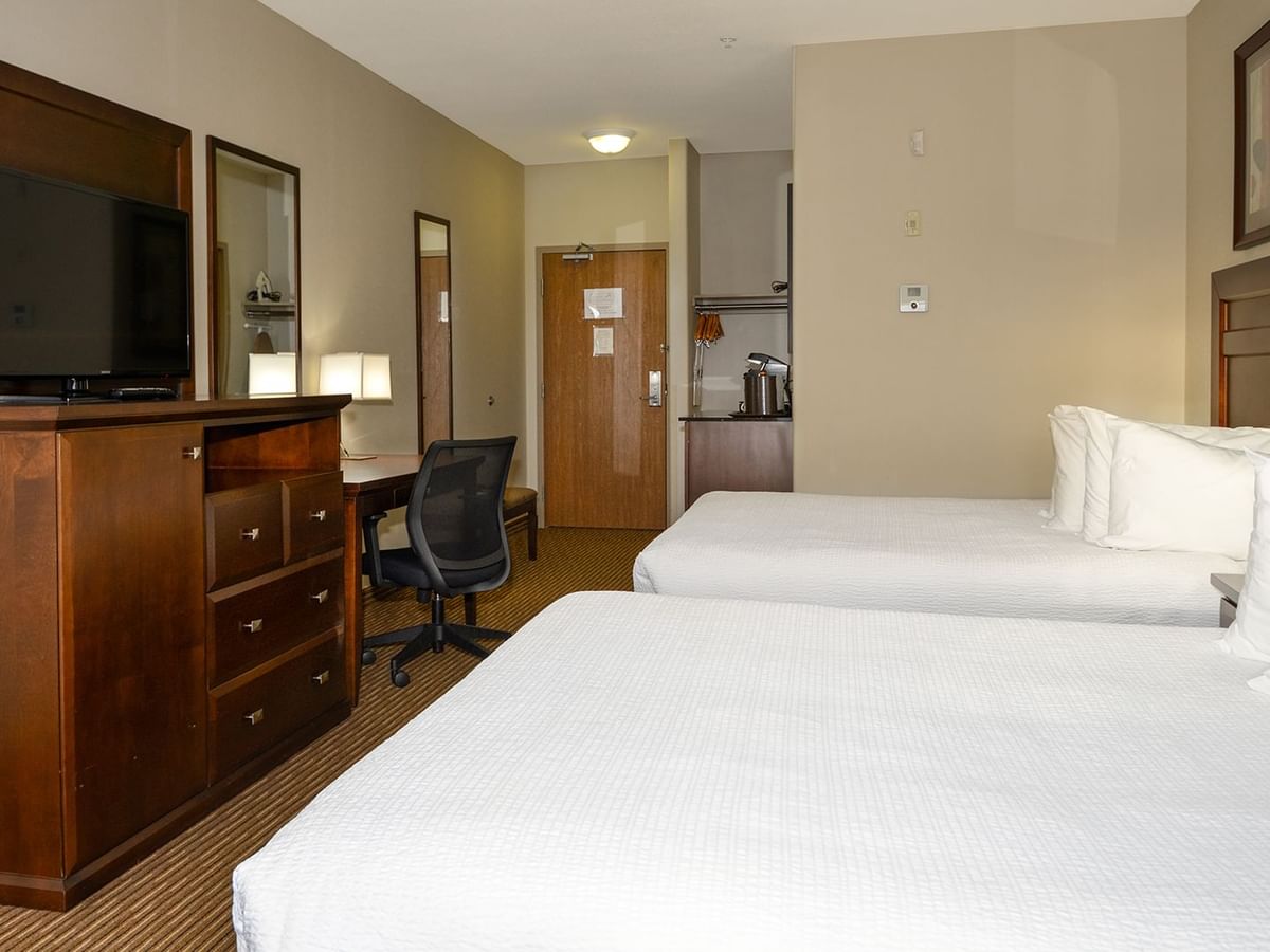 Hotel room with two queen beds, microwave, coffee machine, TV, work desk and chair