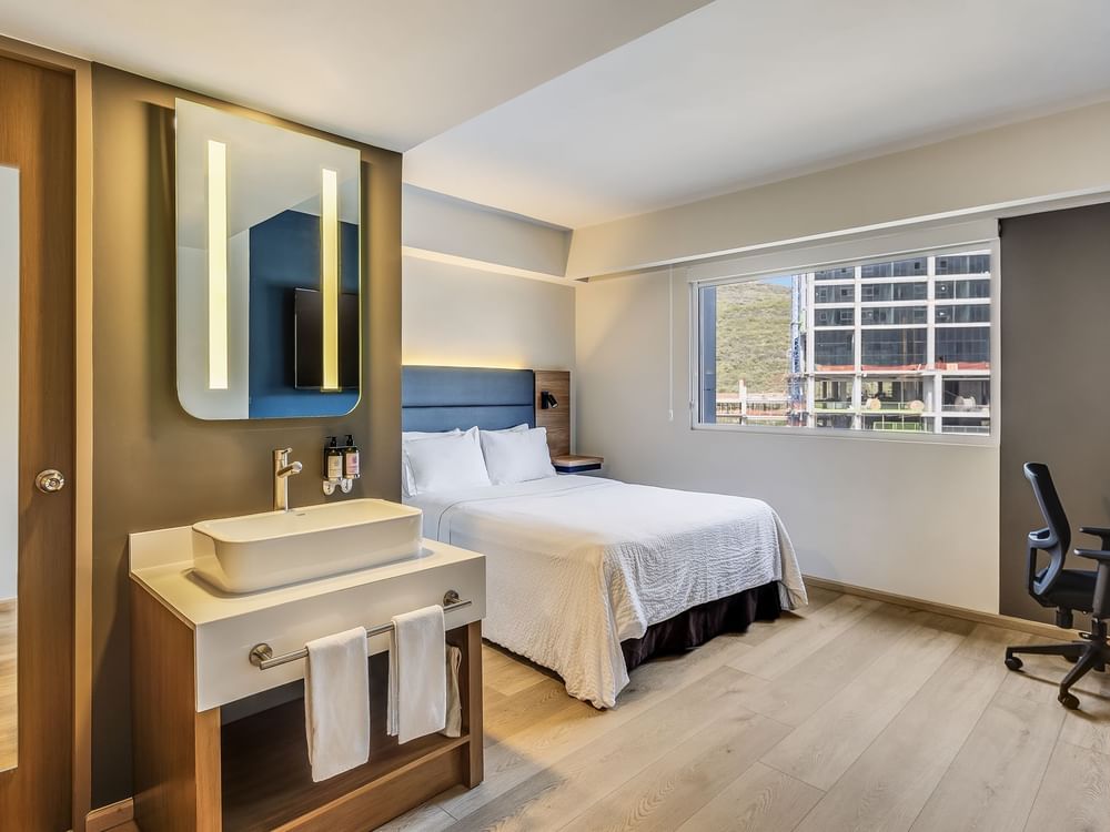 Bed and a Sink area with wooden flooring in Estudio Room at Fiesta Inn