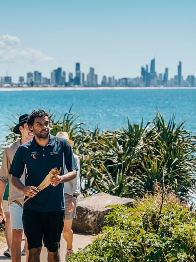 Group walking along the beach at Jellurgal Aboriginal Cultural Centre near Sofitel Brisbane Central