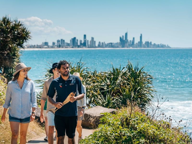 Group walking along the beach at Jellurgal Aboriginal Cultural Centre near Sofitel Brisbane Central