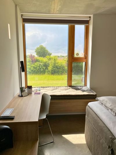 Workdesk with window seating in Long Stay Room at Avaneo Hotel Marktredwitz offering sustainable hotel rooms