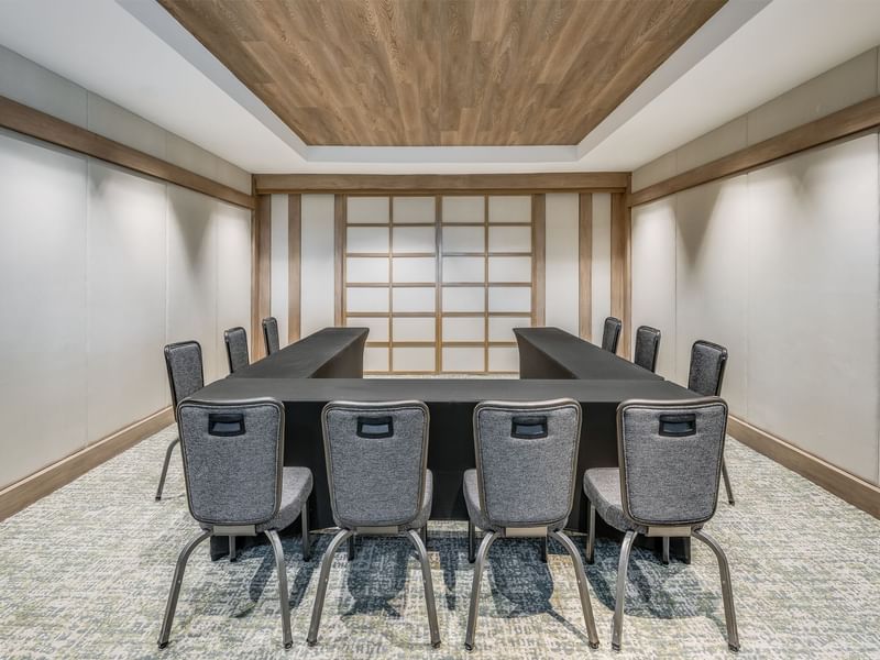 Meeting room with U-shaped table and gray chairs, featuring wooden accents and modern design at Grand Fiesta Americana