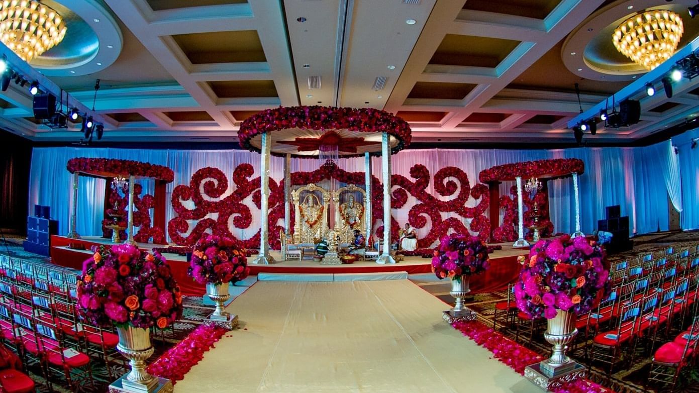 Indian wedding ceremony with red and pink flower deco at The Diplomat Resort