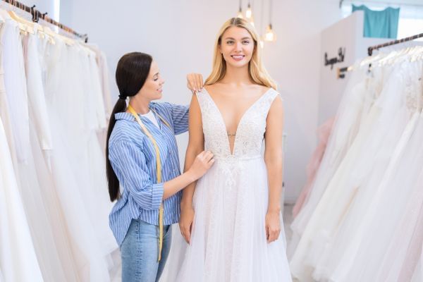 Bride go be in a wedding dress shop being fitted