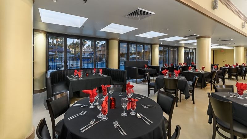 A dining area with round tables set for a meal