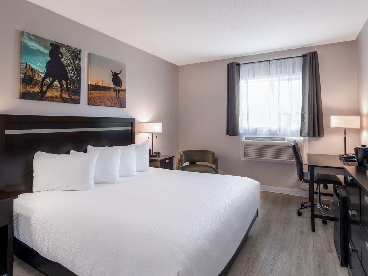King bed at Coast Innisfail Hotel with bedside lamps and seating area